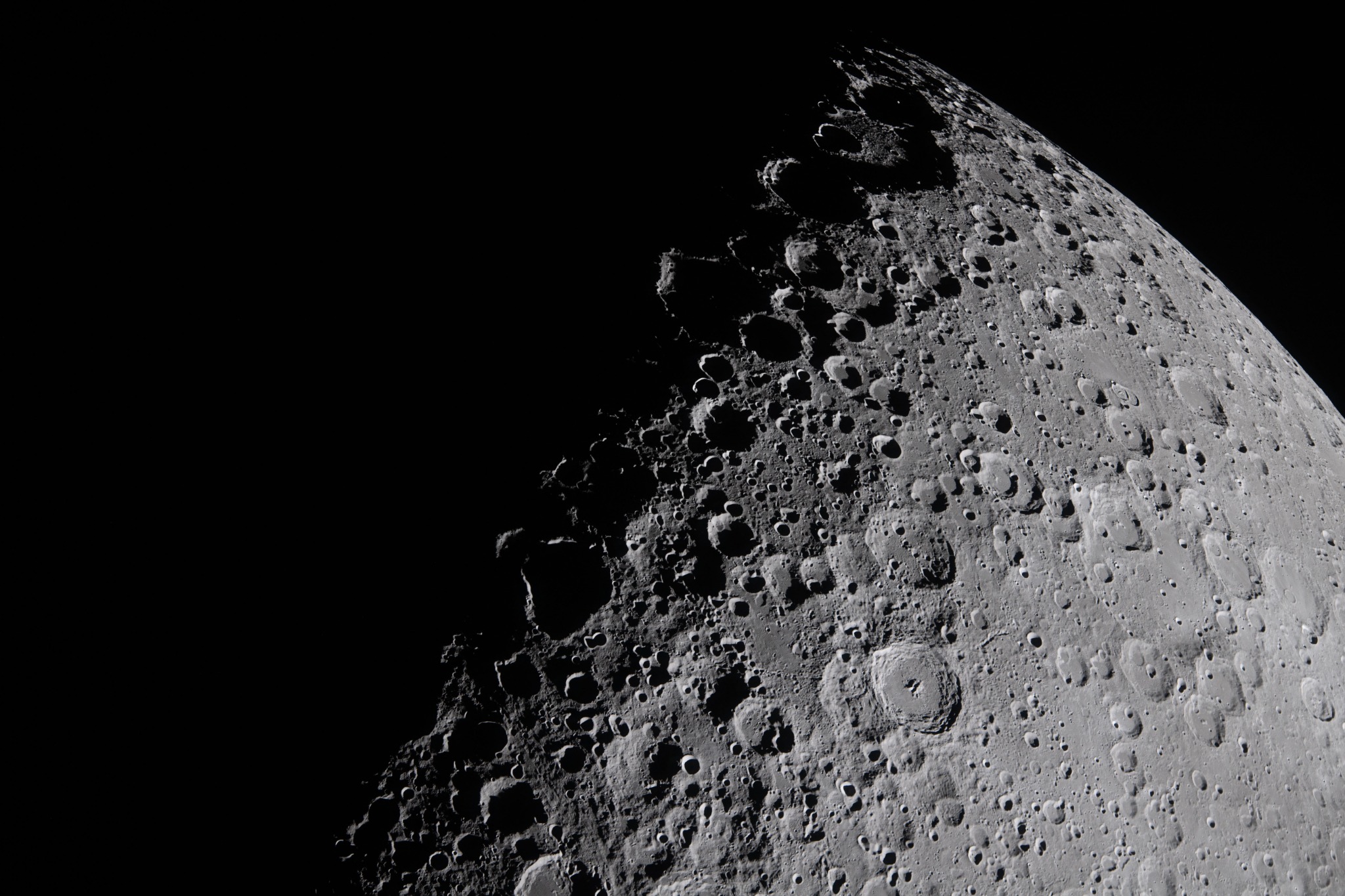 Crateras lunares realçadas pelas sombras próximas à divisão entre a região iluminada e a região escura
